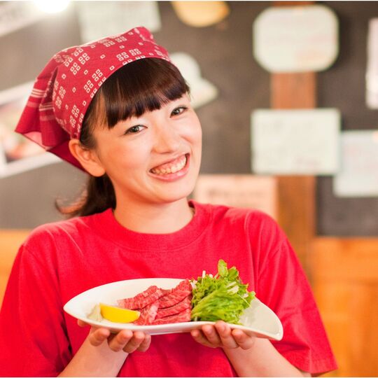 焼肉屋で肉を配膳するスタッフ